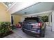 Carport with an Ascenta SUV and a riding toy, offering convenience and protection at 13637 13Th St, Dade City, FL 33525