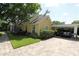 Charming yellow home featuring a covered carport, mature trees, and well maintained lawn at 13637 13Th St, Dade City, FL 33525