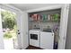 Convenient laundry area with modern appliances and shelving, provides seamless access to the backyard at 13637 13Th St, Dade City, FL 33525