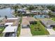 Aerial view of a waterfront home with lush lawn, garden, and a large driveway, nestled in a canal community at 13909 Berkowitz Ave, Hudson, FL 34667