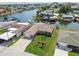 Charming waterfront home features lush landscaping, swaying palm trees, and convenient canal access for boating at 13909 Berkowitz Ave, Hudson, FL 34667