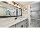 Bathroom features a marble countertop, stylish mirror, and a walk-in shower with black fixtures at 13909 Berkowitz Ave, Hudson, FL 34667