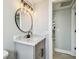 Modern bathroom features a vanity with a marble countertop and decorative round mirror at 13909 Berkowitz Ave, Hudson, FL 34667