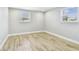 Bright bedroom featuring wood-look tile flooring, neutral paint, and two windows at 13909 Berkowitz Ave, Hudson, FL 34667