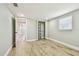A bright bedroom featuring wood-look floors, closet and open door to hallway at 13909 Berkowitz Ave, Hudson, FL 34667