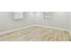 Bright bedroom with wood-look tile flooring and two windows at 13909 Berkowitz Ave, Hudson, FL 34667