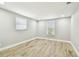 A spacious bedroom with wood-look floors and two windows at 13909 Berkowitz Ave, Hudson, FL 34667