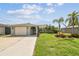Charming single-story home with a well-manicured lawn and mature palm trees at 13909 Berkowitz Ave, Hudson, FL 34667