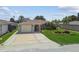 Charming single-story home featuring a front yard, large driveway, attached garage, and well-maintained landscaping at 13909 Berkowitz Ave, Hudson, FL 34667