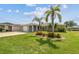 Charming home with well-manicured lawn, mature palms, and colorful flowerbeds at 13909 Berkowitz Ave, Hudson, FL 34667