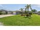 Charming home with a well-manicured lawn, mature palms, and colorful flowerbeds at 13909 Berkowitz Ave, Hudson, FL 34667