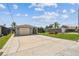 A single garage detached home with a long concrete driveway and manicured front lawn lined with palm trees at 13909 Berkowitz Ave, Hudson, FL 34667
