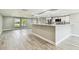 Open concept kitchen and living area with hardwood floors, white cabinetry, and island with marble countertop at 13909 Berkowitz Ave, Hudson, FL 34667