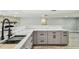 Finished basement kitchen features light gray cabinets, marble countertops, and a stylish black faucet at 13909 Berkowitz Ave, Hudson, FL 34667