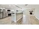 Modern kitchen features stainless steel appliances, white cabinetry, and a center island with bar seating at 13909 Berkowitz Ave, Hudson, FL 34667
