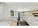 Close-up of the kitchen sink and marble countertop, overlooking an outdoor view at 13909 Berkowitz Ave, Hudson, FL 34667