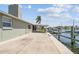 A view of the spacious patio overlooking the canal, boat lift, and waterfront at 13909 Berkowitz Ave, Hudson, FL 34667