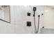 Close-up of modern shower with white marble and sleek black fixtures at 13909 Berkowitz Ave, Hudson, FL 34667