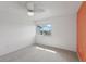 Simple, sunlit bedroom with neutral carpet, ceiling fan, and a view from the window at 14800 Walsingham Rd # 1215, Largo, FL 33774