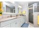 Bright bathroom featuring double sinks, marble countertops, and a walk-in shower with neutral tile and glass door at 1626 Terra Ceia Bay Cir # 6, Palmetto, FL 34221