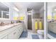 Bright bathroom featuring double sinks, marble countertops, and a walk-in shower with neutral tile and glass door at 1626 Terra Ceia Bay Cir # 6, Palmetto, FL 34221