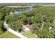 Stunning aerial view of a home surrounded by lush greenery and a serene lake at 1753 Ranchette Rd, Wesley Chapel, FL 33543