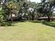 Spacious backyard with mature trees, shed and outbuildings and lush green lawns at 1753 Ranchette Rd, Wesley Chapel, FL 33543