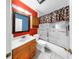 A colorful bathroom with a shower-tub combo and an oak vanity at 1753 Ranchette Rd, Wesley Chapel, FL 33543