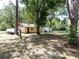 Exterior home with a covered porch, adjacent to trees at 1753 Ranchette Rd, Wesley Chapel, FL 33543