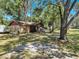 Landscaped yard with charming home featuring a screened patio at 1753 Ranchette Rd, Wesley Chapel, FL 33543