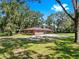Beautiful single-story home with lush green lawns shaded by mature trees at 1753 Ranchette Rd, Wesley Chapel, FL 33543