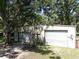 Detached two-car garage with metal siding, surrounded by mature trees offering ample space at 1753 Ranchette Rd, Wesley Chapel, FL 33543