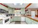 Cozy kitchen featuring vintage green cabinets, white appliances, and a bright skylight, ideal for a charming, retro aesthetic at 1753 Ranchette Rd, Wesley Chapel, FL 33543