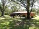 Lush backyard with mature trees providing ample shade and a serene ambiance at 1753 Ranchette Rd, Wesley Chapel, FL 33543