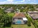 Aerial view of a home with a screened-in pool and spacious backyard surrounded by lush landscaping at 19409 Wingrove Ln, Lutz, FL 33558