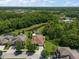 Aerial view of home featuring a screened-in pool, lush backyard, mature landscaping and views of a pond at 19409 Wingrove Ln, Lutz, FL 33558