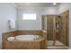 Bathroom featuring a soaking tub, glass-enclosed shower, and tile accents at 19409 Wingrove Ln, Lutz, FL 33558