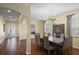 Spacious dining room featuring hardwood floors, modern chandelier, and an open layout into the front foyer at 19409 Wingrove Ln, Lutz, FL 33558