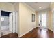 Spacious entryway featuring hardwood floors, decorative glass door, and a view to an adjacent bathroom at 19409 Wingrove Ln, Lutz, FL 33558
