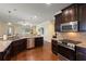 Open concept kitchen with stainless steel appliances, granite countertops, and wood flooring at 19409 Wingrove Ln, Lutz, FL 33558