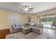 Cozy living room with a ceiling fan, large sectional sofa, and a view of the pool at 19409 Wingrove Ln, Lutz, FL 33558
