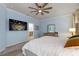 Main bedroom with a ceiling fan, mounted TV, en-suite bathroom, and neutral décor at 19409 Wingrove Ln, Lutz, FL 33558