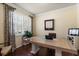Bright office featuring hardwood floors, a large desk, plantation shutters, and stylish decor at 19409 Wingrove Ln, Lutz, FL 33558