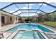 Gorgeous screened-in pool and spa with a spacious patio, lounge furniture, and lush backyard views at 19409 Wingrove Ln, Lutz, FL 33558