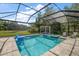 Beautiful screened-in pool area featuring a spa, cabana, and scenic backyard views at 19409 Wingrove Ln, Lutz, FL 33558