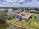 Expansive aerial view of a beautiful home featuring a screened pool and lush landscaping, situated near a picturesque lake at 22925 Collridge Dr, Land O Lakes, FL 34639