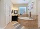 Bright bathroom featuring a soaking tub with tile surround and granite vanity at 22925 Collridge Dr, Land O Lakes, FL 34639