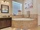 Bathroom featuring a large soaking tub with tile surround and granite vanity at 22925 Collridge Dr, Land O Lakes, FL 34639