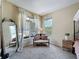 Bright bedroom with large windows, soft carpet, and a cozy seating area at 22925 Collridge Dr, Land O Lakes, FL 34639