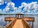 Picturesque waterfront dock with a gazebo, offering stunning views of the calm lake and clear blue sky at 22925 Collridge Dr, Land O Lakes, FL 34639